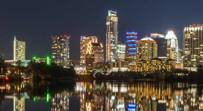 Image of the night skyline reflected over the water in Austin, Texas, United States